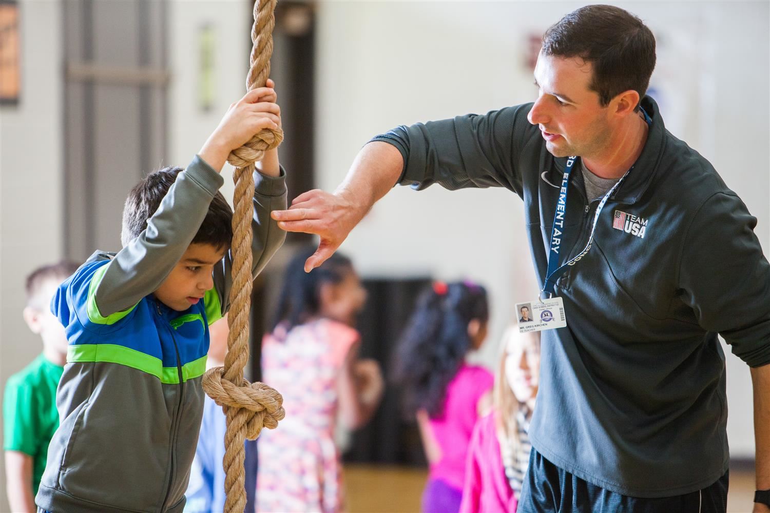 PE teacher and student climbing a rope PE teacher and student climbing a rope